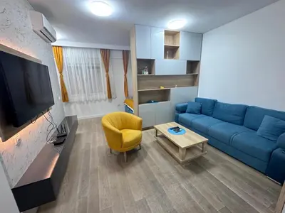 a living room with a blue couch and a yellow chair at Apartment Oaza in Budva