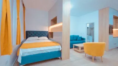 a bedroom with a blue bed and a blue couch at Apartment Oaza in Budva