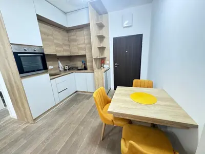 a kitchen and dining room with a wooden table and chairs at Apartment Oaza in Budva