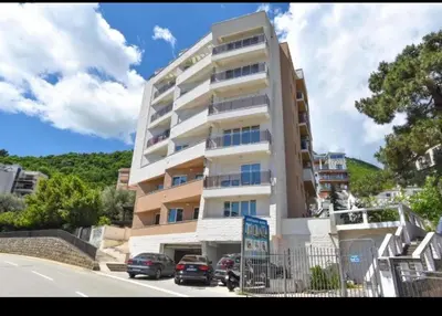 a tall building with cars parked in front of it at Apartment Oaza in Budva