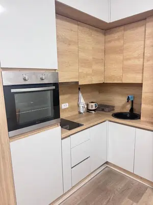 a kitchen with white cabinets and a black microwave at Apartment Oaza in Budva