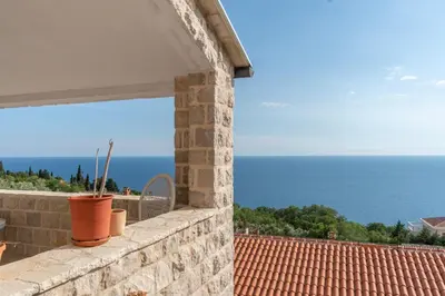 a stone wall with a view of the ocean at Emilys View Rezevici in Katun