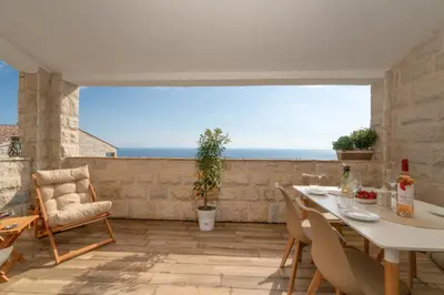 a patio with a table and chairs and the ocean at Emilys View Rezevici in Katun