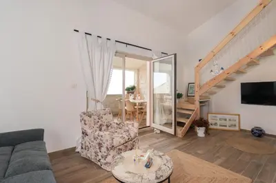 a living room with a couch and a staircase at Emilys View Rezevici in Katun