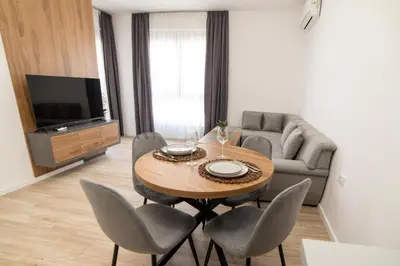 a living room with a table and chairs and a couch at LA PERLA apartments 16 in Ulcinj