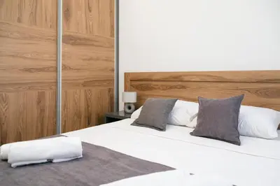 a bedroom with a bed with white sheets and pillows at LA PERLA apartments 16 in Ulcinj