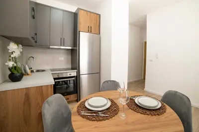 a kitchen and dining room with a wooden table and chairs at LA PERLA apartments 16 in Ulcinj