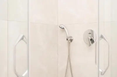 a shower in a white bathroom with a shower head at LA PERLA apartments 16 in Ulcinj