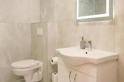 a white bathroom with a toilet and a sink at LA PERLA apartments 16 in Ulcinj