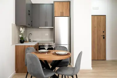 a kitchen with a wooden table and gray chairs at LA PERLA apartments 16 in Ulcinj
