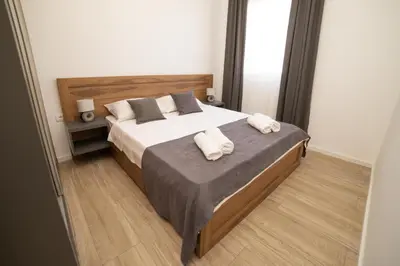a bedroom with a bed with two towels on it at LA PERLA apartments 16 in Ulcinj
