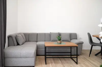 a living room with a gray couch and a table at LA PERLA apartments 16 in Ulcinj