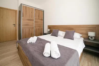 a bedroom with a large bed with white towels on it at LA PERLA apartments 14 in Ulcinj