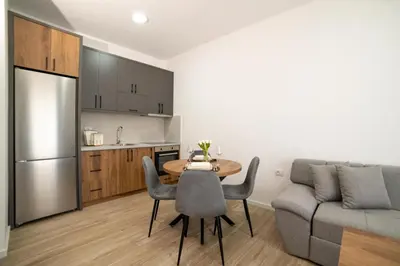 a kitchen and dining room with a table and a couch at LA PERLA apartments 14 in Ulcinj