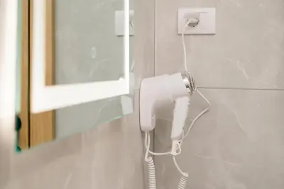 a white phone hanging on a wall in a bathroom at LA PERLA apartments 14 in Ulcinj