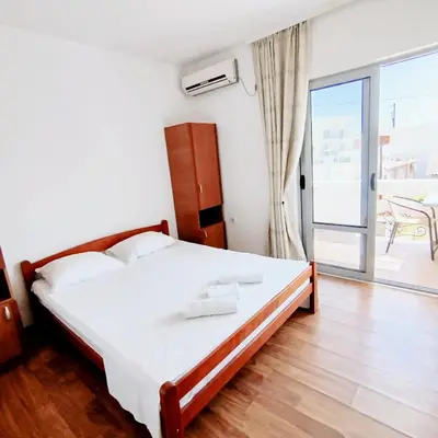 a bedroom with a bed and a balcony at Apartments Hija in Donji Štoj