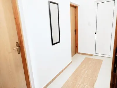 a hallway with a white door and a tile floor at Apartments Hija in Donji Štoj