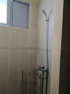 a shower in a tiled bathroom with a window at Доброморе Будва in Budva