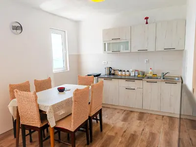 a kitchen with a table and chairs in a room at Zora Apartments in Bar