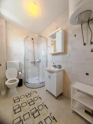 a bathroom with a shower and a toilet and a sink at Zora Apartments in Bar