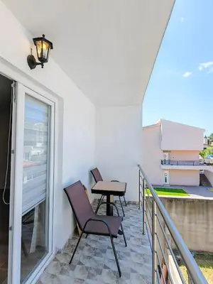 a patio with two chairs and a table on a balcony at Zora Apartments in Bar