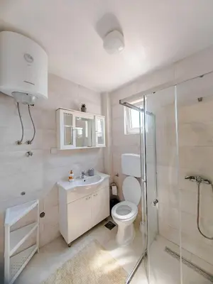 a bathroom with a toilet and a sink and a shower at Zora Apartments in Bar