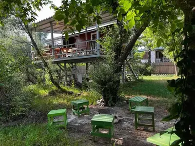 a house with green benches in the yard at Kucica obala in Železnička Stanica Zeta