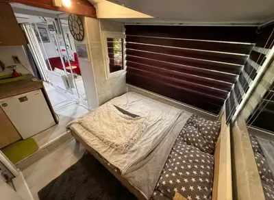a bed in the back of a tiny house at Kucica obala in Železnička Stanica Zeta