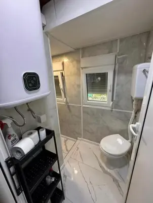a small bathroom with a toilet and a window at Kucica obala in Železnička Stanica Zeta