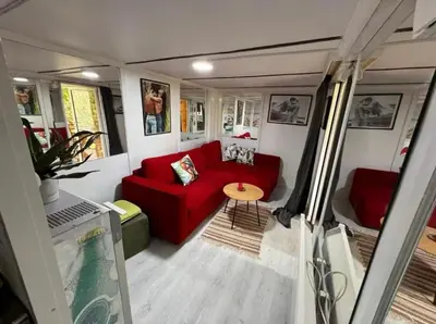 a living room with a red couch and a table at Kucica obala in Železnička Stanica Zeta
