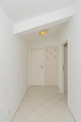 an empty room with white walls and white tile floors at Vanila Apartmani in Sutomore