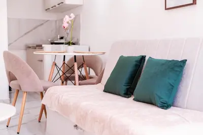 a white couch with two blue pillows in a room at Mia Studio Apartment in Budva