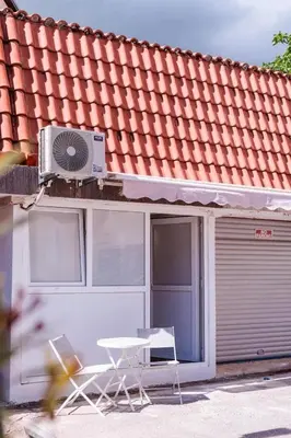 a patio with a table and a fan on a building at Mia Studio Apartment in Budva