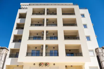 a white apartment building with balconies at Millennium Apartments Budva in Budva