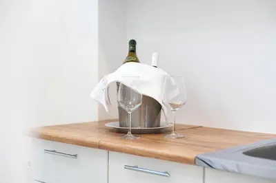 a bottle of wine and two wine glasses on a counter at Millennium Apartments Budva in Budva