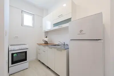 a white kitchen with a sink and a refrigerator at Millennium Apartments Budva in Budva