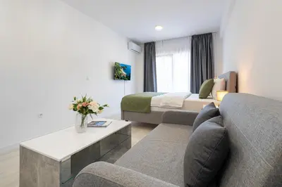 a hotel room with a couch and a bed at Millennium Apartments Budva in Budva