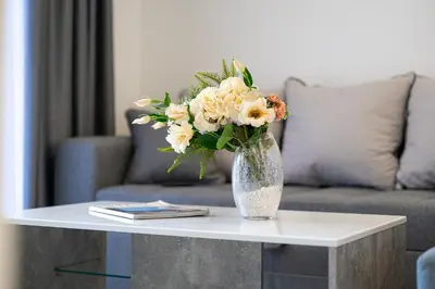 a vase of flowers on a table in a living room at Millennium Apartments Budva in Budva