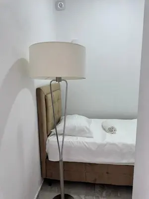 a lamp sitting next to a bed in a room at Best Apartments in Ulcinj