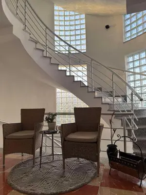 two chairs and a table in a room with a staircase at Best Apartments in Ulcinj