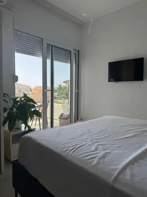 a bedroom with a bed and a flat screen tv at Best Apartments in Ulcinj