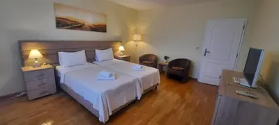 a bedroom with a large white bed and a television at Three bedrooms family apartment with sea view Sveti Stefan in Sveti Stefan