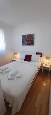a bedroom with a large white bed with two towels on it at Three bedrooms family apartment with sea view Sveti Stefan in Sveti Stefan