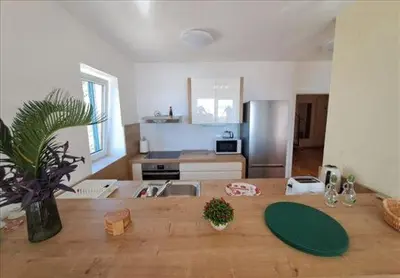 a kitchen with a wooden table in front of a kitchen at Three bedrooms family apartment with sea view Sveti Stefan in Sveti Stefan