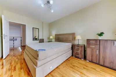 a large bedroom with a bed and wooden floors at Three bedrooms family apartment with sea view Sveti Stefan in Sveti Stefan