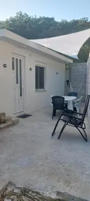 a table and a chair in front of a house at White apartment in Sutomore
