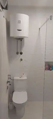 a white bathroom with a toilet and a shower at White apartment in Sutomore
