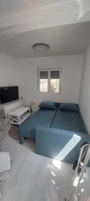 a bedroom with a large blue bed in a room at White apartment in Sutomore