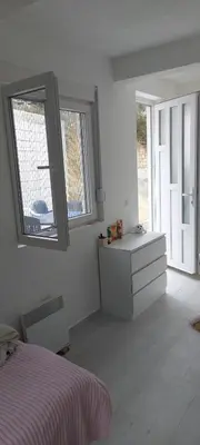 a white bedroom with a bed and a mirror at White apartment in Sutomore