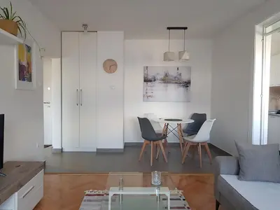 a living room with a table and chairs at Spacious and comfortable apartment in Podgorica